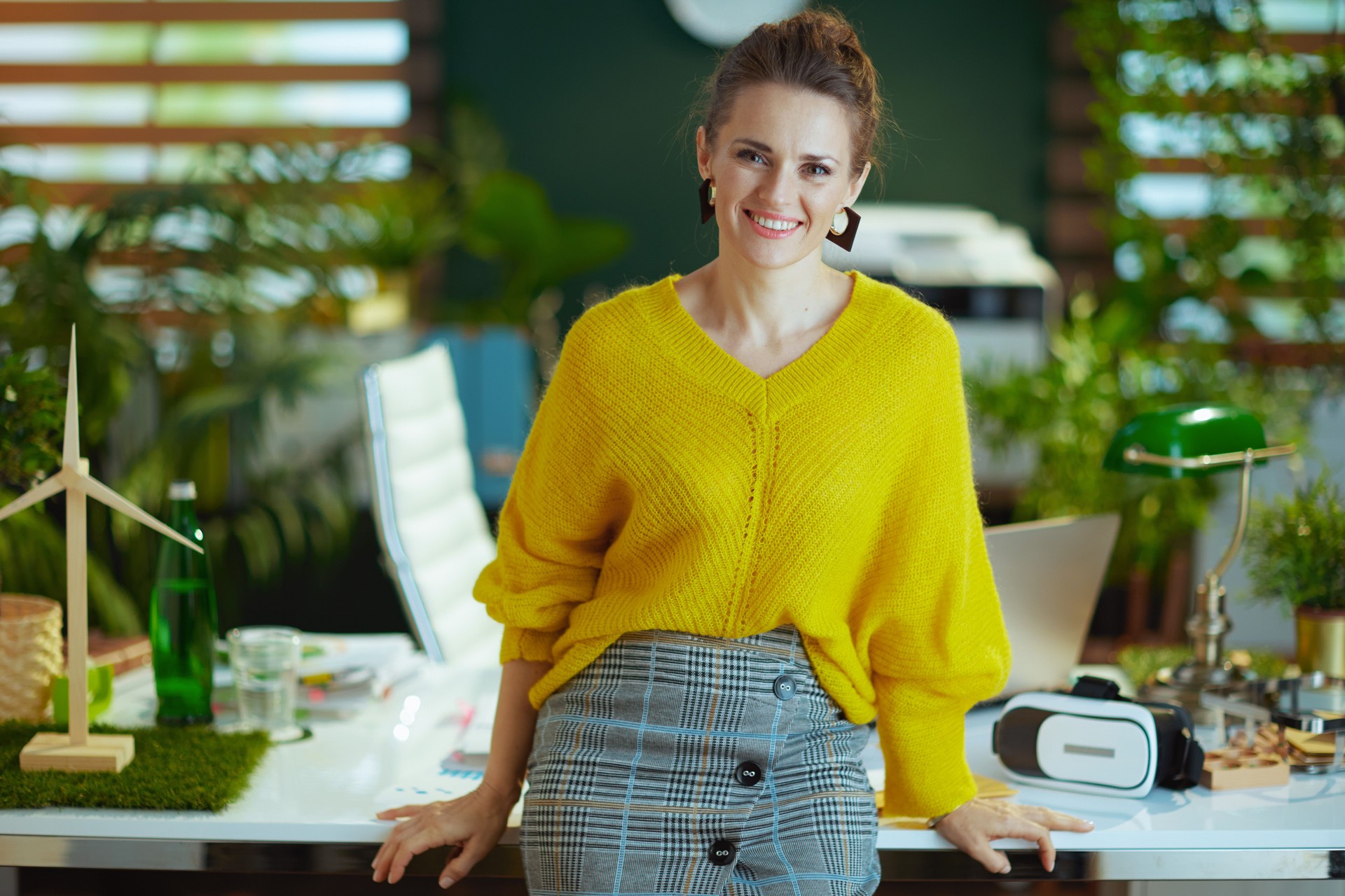 smiling stylish business owner woman standing in green office